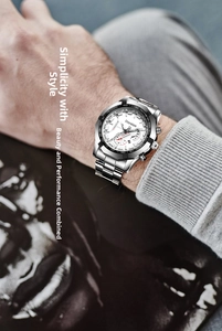 Close-up of a men's silver steel watch with a white tachymeter dial on a male wrist