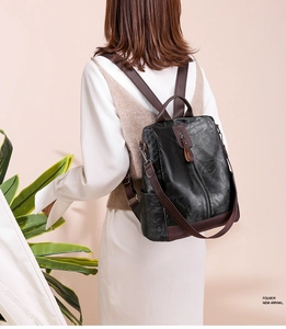 Detailed close-up of a vintage PU leather backpack with contrast brown straps on a model