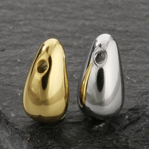 Polished gold and silver titanium steel water drop pendants on grey stone surface