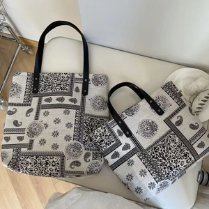 Detail of vintage paisley patchwork tote bags with black leather handles and metal rivets