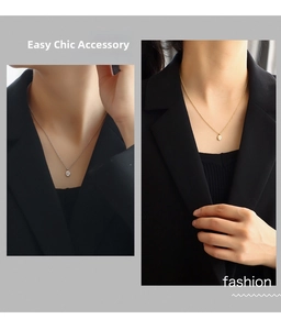 Detail view of oval star pendant necklace styled with a black blazer for a chic look