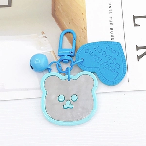 Detail of light blue cartoon bear mirror keychain with heart charm and small bell