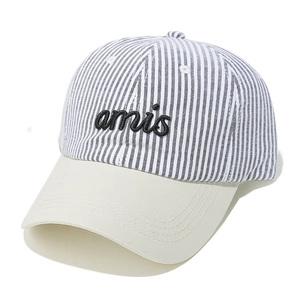 Close-up of baseball cap featuring black and white striped crown and embroidered amis text