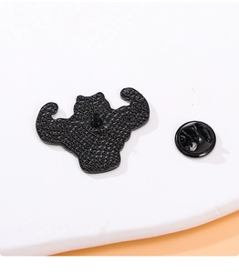 Detail view of the muscular frog pin's back texture with secure black butterfly clutch