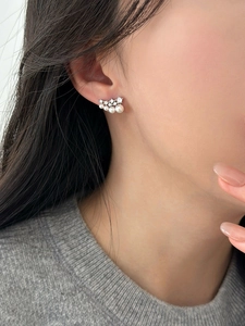 Detail shot of silver stud earrings with gradient pearls and sparkling zircon accents