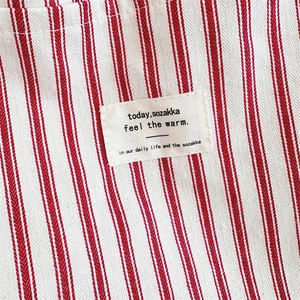 Close-up of red and white striped canvas fabric with high-quality cotton brand label
