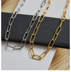 Detail of heavy paperclip chain necklaces in gold and silver finishes for layering