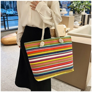 Lifestyle shot of large striped canvas tote bag with thick rope handles on shoulder