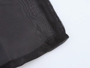 Macro detail of the elegant black organza fabric with fine stitching on the shirt collar