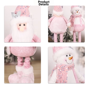 Detail shot of plush pink Christmas dolls with sequins, knit fabric and silver bows
