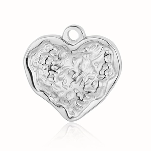 Detail shot of a silver heart pendant featuring a unique hammered lava-like metal texture