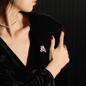 Close-up of bird-shaped brooch with sparkling rhinestones and gems on black fabric