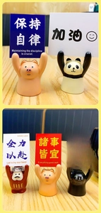 Close-up of creative resin animal photo holders with motivational cards on a wood desk