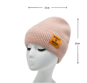 Pink knit beanie with orange letter patch showing 21cm width and 23cm height dimensions