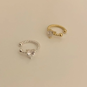 Detailed view of silver and gold heart zircon ear cuffs with beaded texture design
