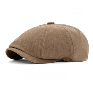 Detailed view of khaki herringbone pattern and button top on classic newsboy cap