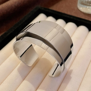 Detail of layered silver wide open bangle with high-polished mirror finish surface