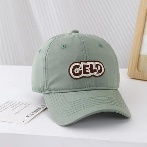Detail of light green baseball cap with CELD embroidery on minimalist background