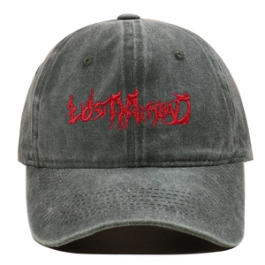 Close-up of red Gothic embroidery on a washed grey cotton denim baseball cap
