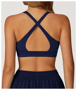 Detail view of navy blue sports bra featuring cross-back straps and breathable fabric