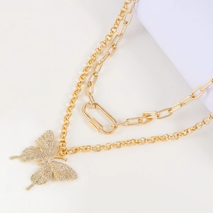 Close-up of gold double-layer chain necklace featuring a crystal butterfly pendant