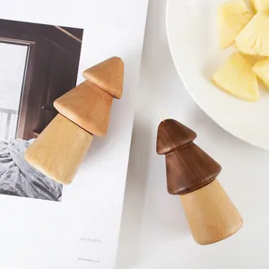 Detail of pine tree shaped wooden toothpick holders in beech and walnut wood finish