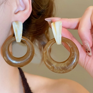 Detail view of large resin hoop earrings with marble pattern and vintage brown finish