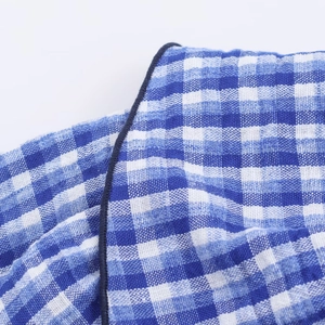 Detailaufnahme von blau-weißem Gingham-Baumwollstoff mit Fokus auf Webart und Nähten