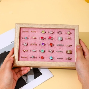 Walnut wood jewelry tray with pink velvet lining displaying multiple rings in hands