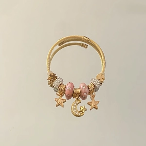 Golden stainless steel twisted cuff bracelet with pink beads and star moon charms