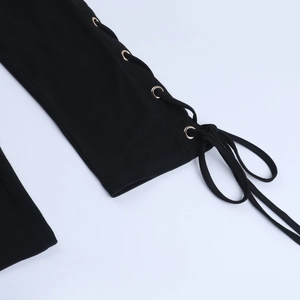Detail of black fabric with metallic eyelets and lace-up craft on a slim jumpsuit