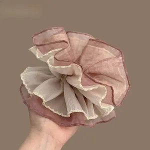 Macro detail of large multilayer chiffon scrunchie in dusty pink and beige mesh