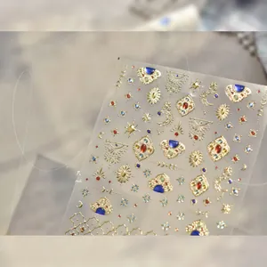Makroaufnahme goldener Boho-Nagelaufkleber mit blauen Steinen und mystischen Motiven