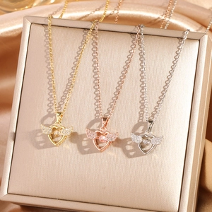 Elegant angel wing heart necklaces in gold, rose gold and silver on silk backdrop