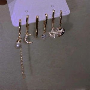 Detail of 6-piece gold plated earring set featuring star, moon, and pearl designs