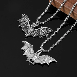 Macro shot of silver bat pendants with textured wings and polished metal finish on box chains