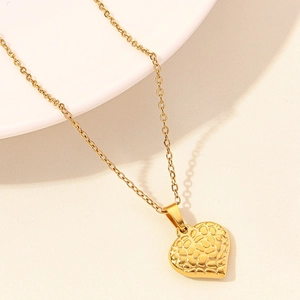 Macro detail of 18k gold plated heart pendant featuring unique textured relief patterns
