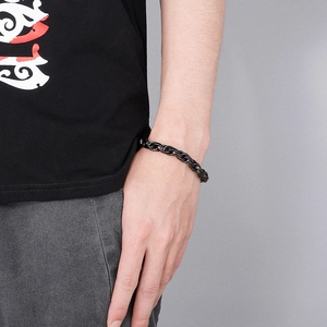 Gros plan d'un bracelet gourmette masculin en acier inoxydable noir au poignet