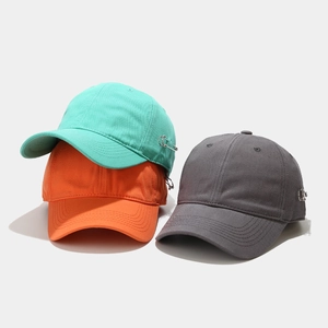Three-color cotton baseball caps stacked showing side metal pin details and texture