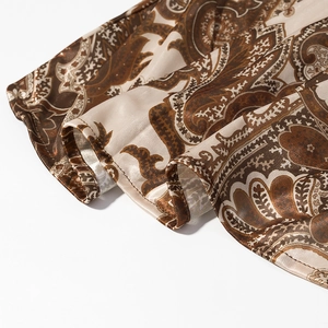 Dettaglio del tessuto paisley simile alla seta con motivi marroni e beige e cuciture fini