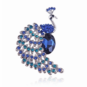 Elegant silver peacock brooch featuring blue crystals and rhinestones with reflection