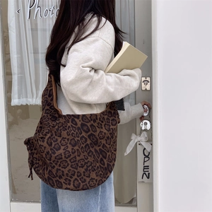 Macro detail of high-capacity leopard print shoulder bag with soft suede-like texture