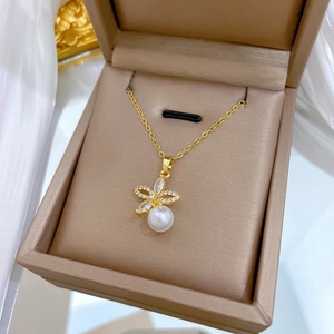Detailed macro view of a gold flower necklace with clear rhinestones and a white pearl