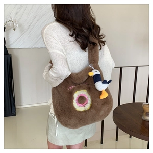 Brown plush tote bag with donut embroidery and seagull charm shown on model's shoulder