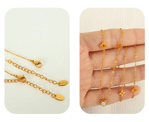Close-up of gold stainless steel necklace featuring clover charms and lobster clasp