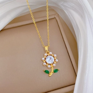 Titanium steel necklace with gold flower pendant, pearls and green crystal in a jewelry box