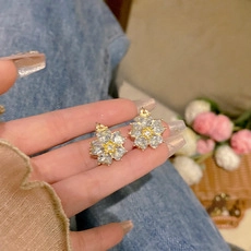 Macro view of S925 silver needle floral earrings with gold trim and crystal petals
