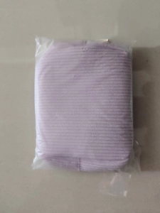 Close-up of light purple ribbed fabric cosmetic bag inside transparent protective packaging