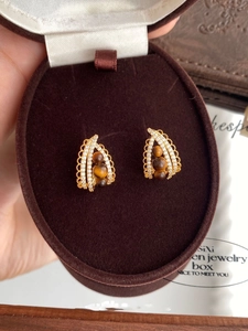 Detail of vintage teardrop earrings with tiger eye stones and zircons in a velvet box