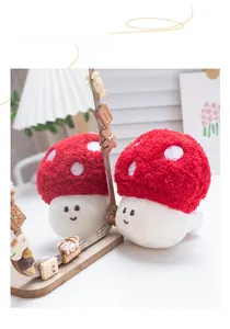 Close-up of red plush mushroom keychain with embroidered dots and a cute smiling face